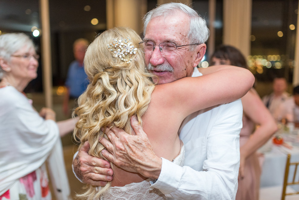 Father of the bride hugs her at the first dance