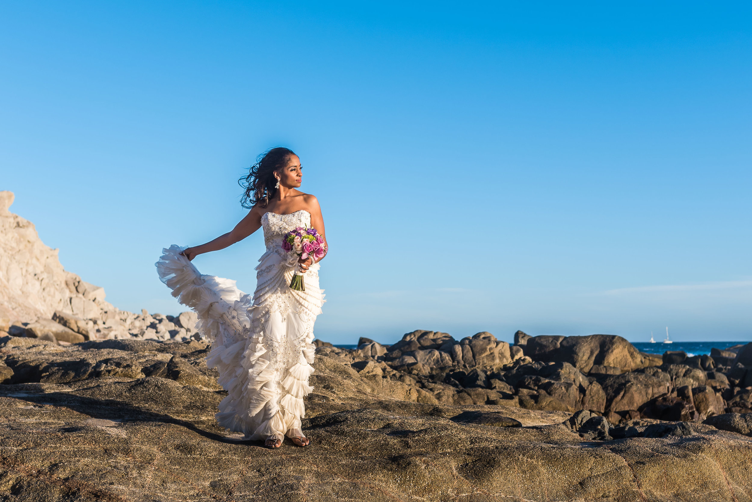  Beautiful bride holding her dress with one hand and the bouquet with the other hand during her photo session with profesional prhotographer GVphotographer 