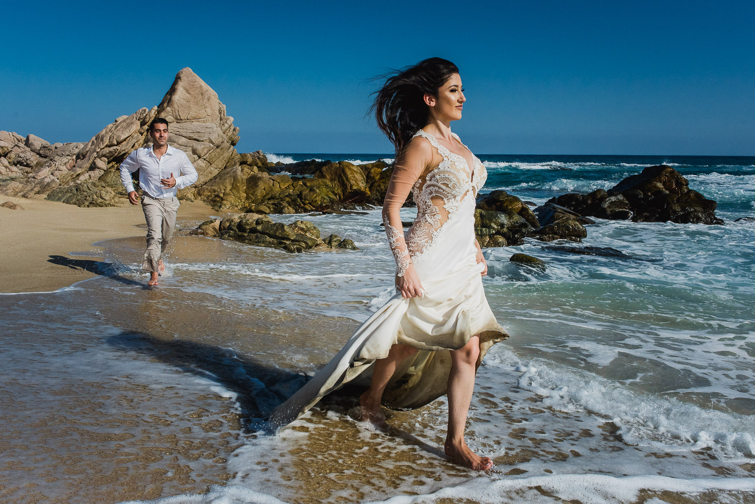  Running on the beach bride and groom during a trash the dress session at Sheraton Los Cabos 