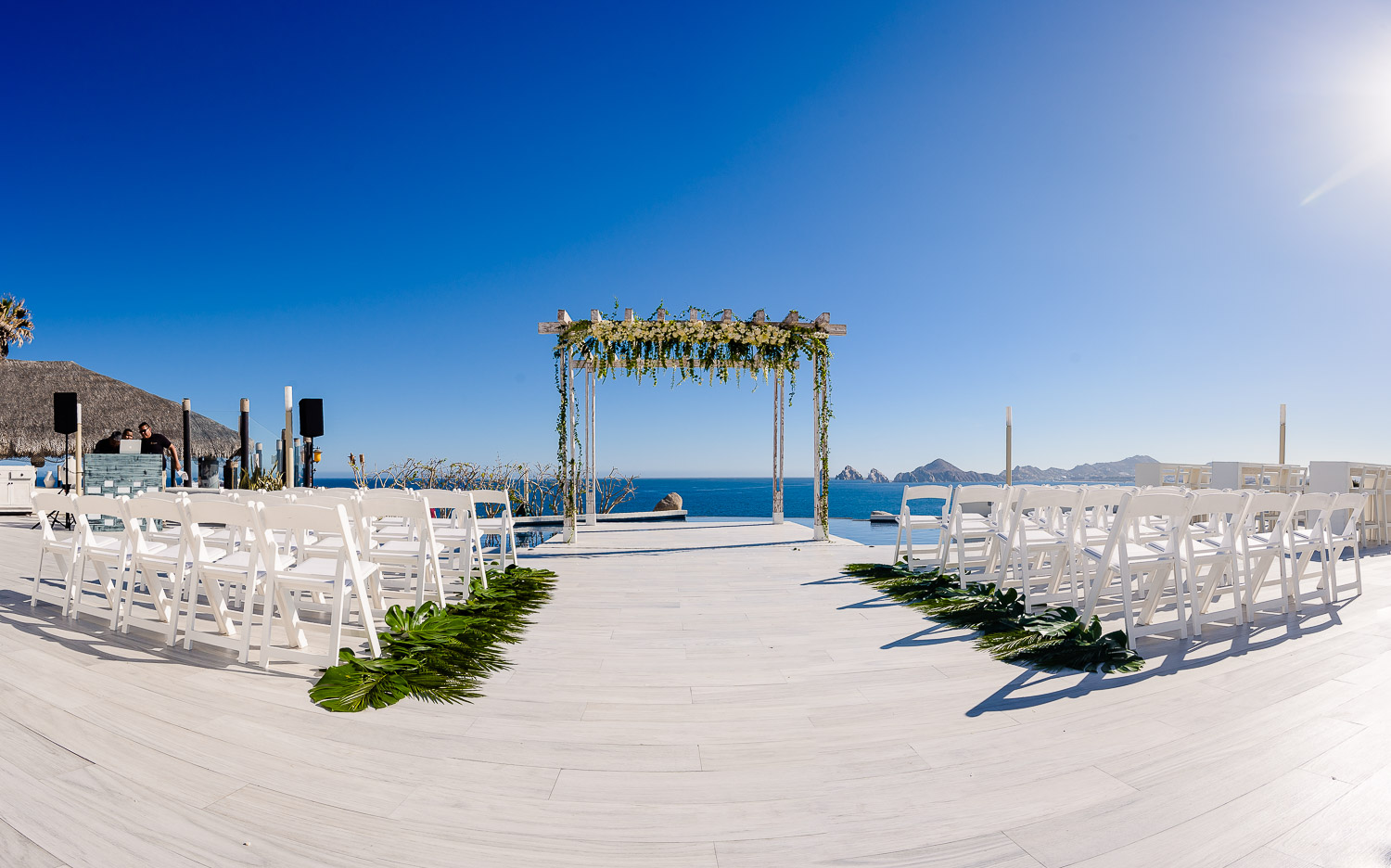  Sunset Monalisa wedding set up. Ocean view, wedding hopa and white chairs 