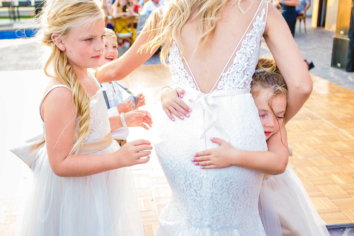  Two lovely kids are hugging the stunning bride dressed in white gown. GVphotographer is an amazing Los Cabos, Mexico destination wedding professional photographer 