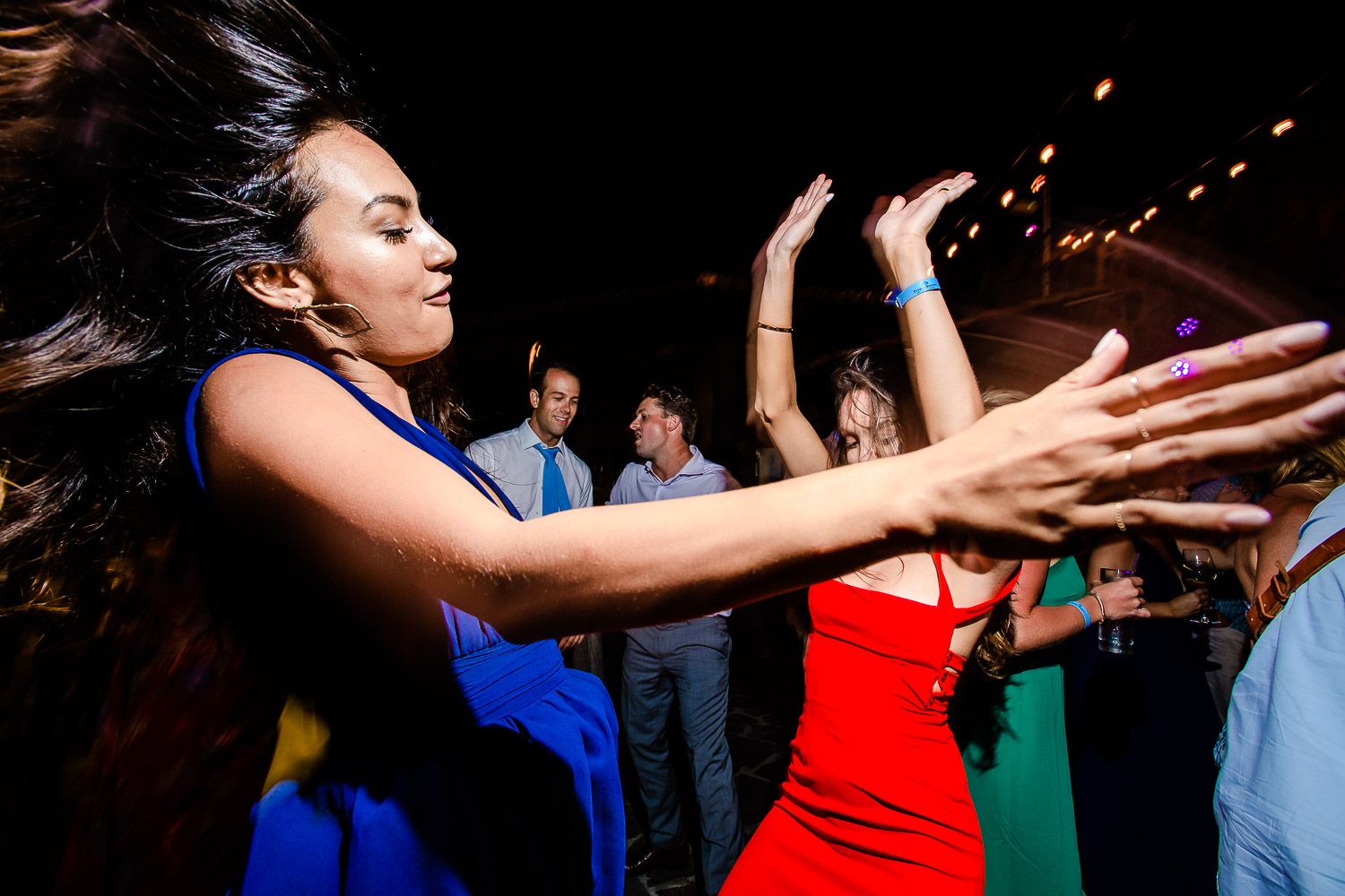  A beautiful woman full of energy is enjoying the evening party at the dance fllor . Other guests are also dancing on the dance floor at the party- destination wedding of the wonderful couple Chelsea and Jay at the beautiful Pueblo Bonito Sunset Beac