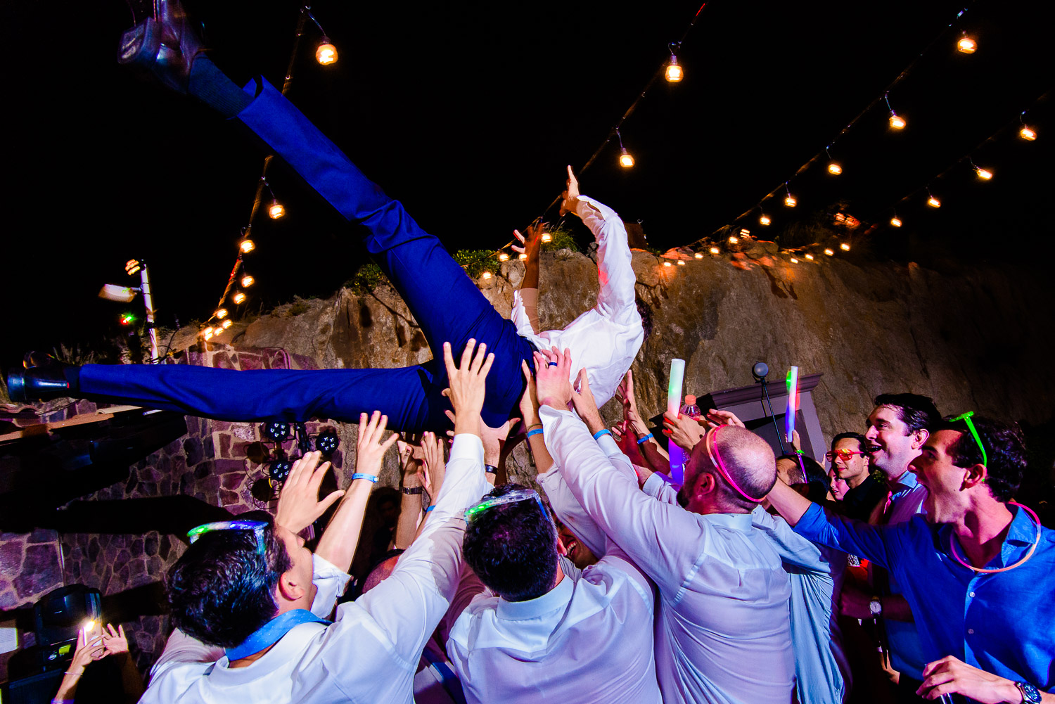  The groom is enjoying his evening party dance while being held by his friends. Other guests are also dancing on the dance floor at the party- destination wedding of the wonderful couple Chelsea and Jay at the beautiful Pueblo Bonito Sunset Beach. GV