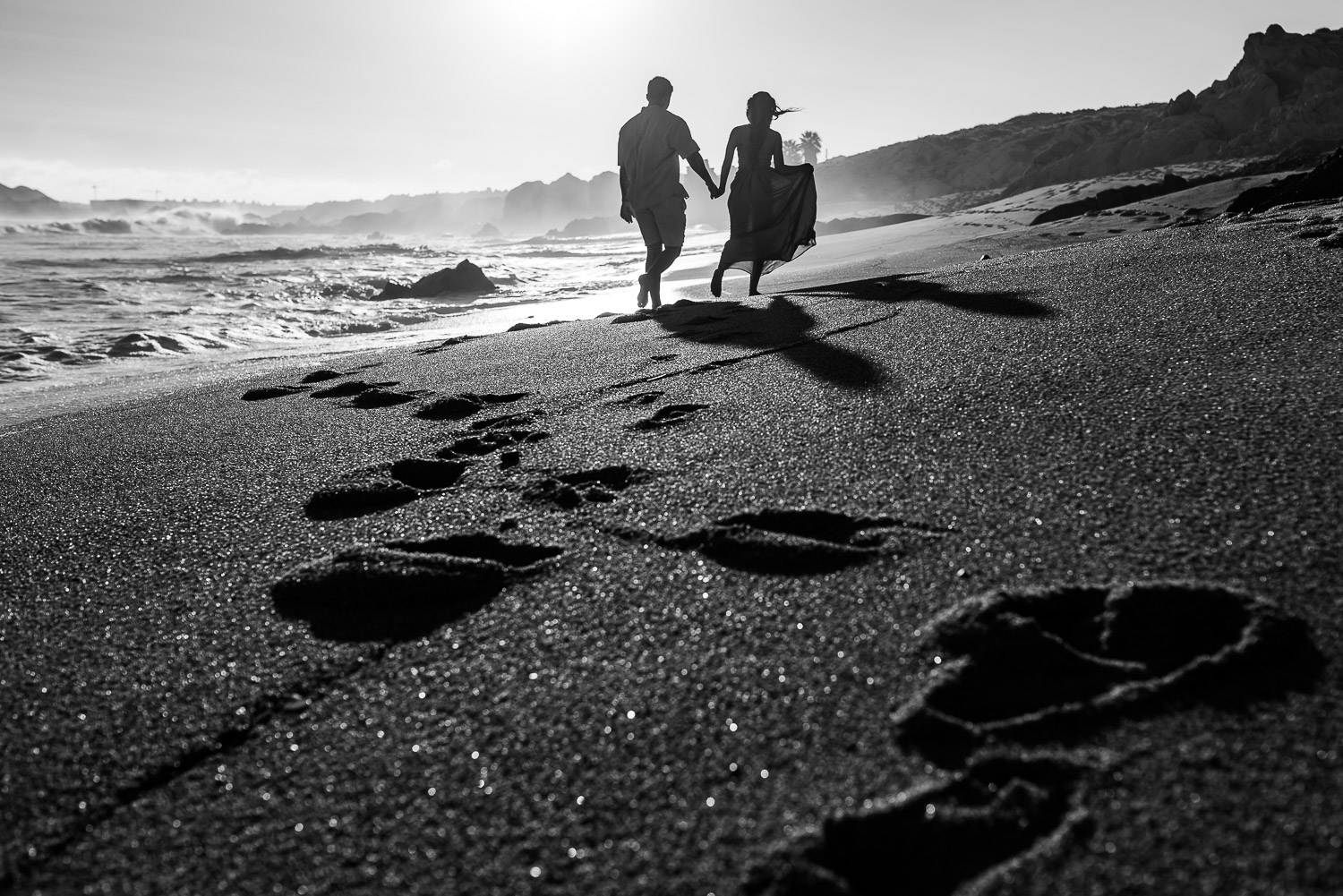  Young engaged couple walk along a desert beach in Baja, Mexico 