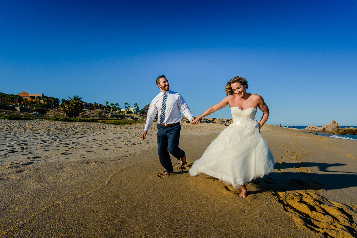  Bride and groom running on the beach during their one year photo anniversary at the Sheraton´s beach 