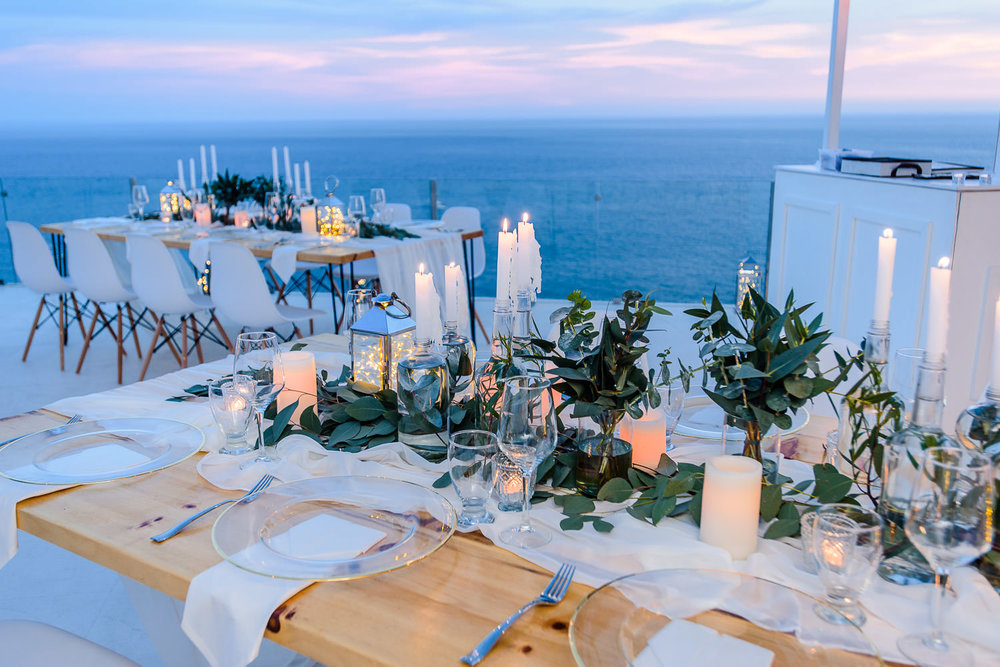 Recepcion boho wedding tables with candles and light and the view of the Pacific Ocean capturedd by professional Cabo wedding photographer GVphotographer. Pedregal Vila Wedding