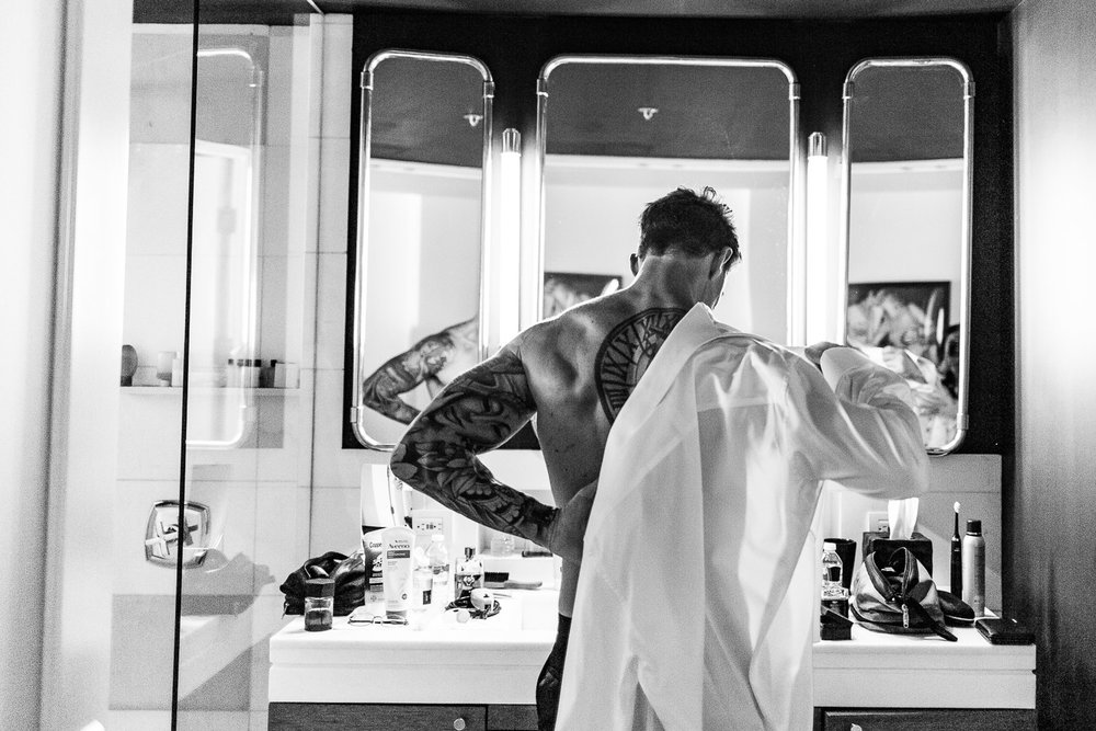 Groom getting ready in fron of the mirror