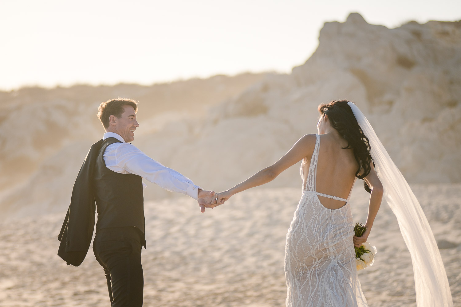 bride and groom walking on the beach during their photo session right after the ceremony (Copy)