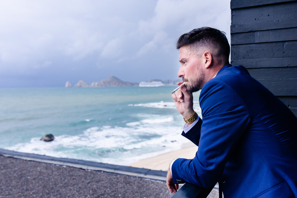 groom smoking a cigarrete on the terrace of the hotel a few minutes before his wedding ceremony