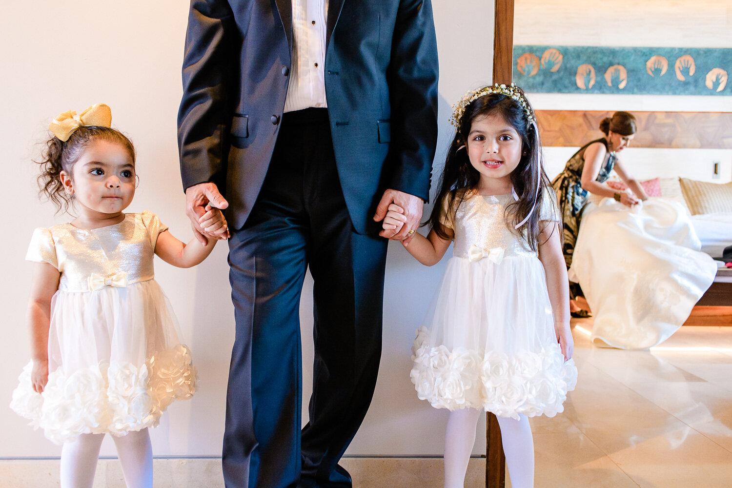 flower girls posing before the ceremony with the father of the bride, mean while mother of the bride is fixing the wedding dress (Copy)