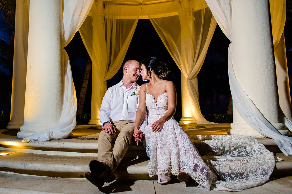 Bride and groom sitting under the gazebo during their wedding photos at the all inclusive Hyatt Ziva Resort