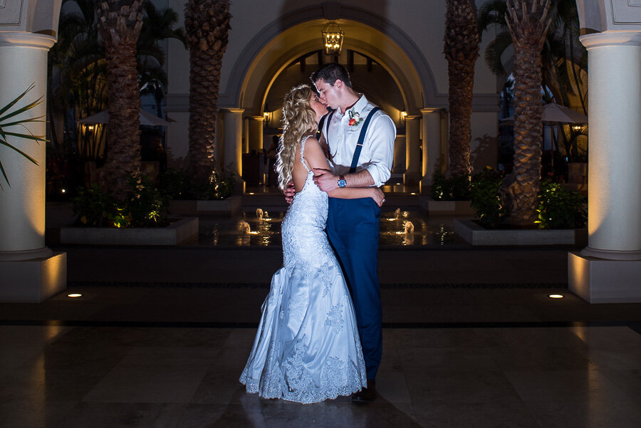 Bride and groom hugging and kissing during their photo session at Dream Los Cabos