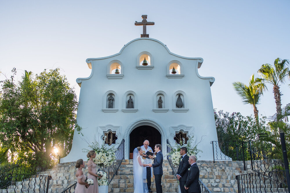 Wedding sunset ceremony with the church behind the couple