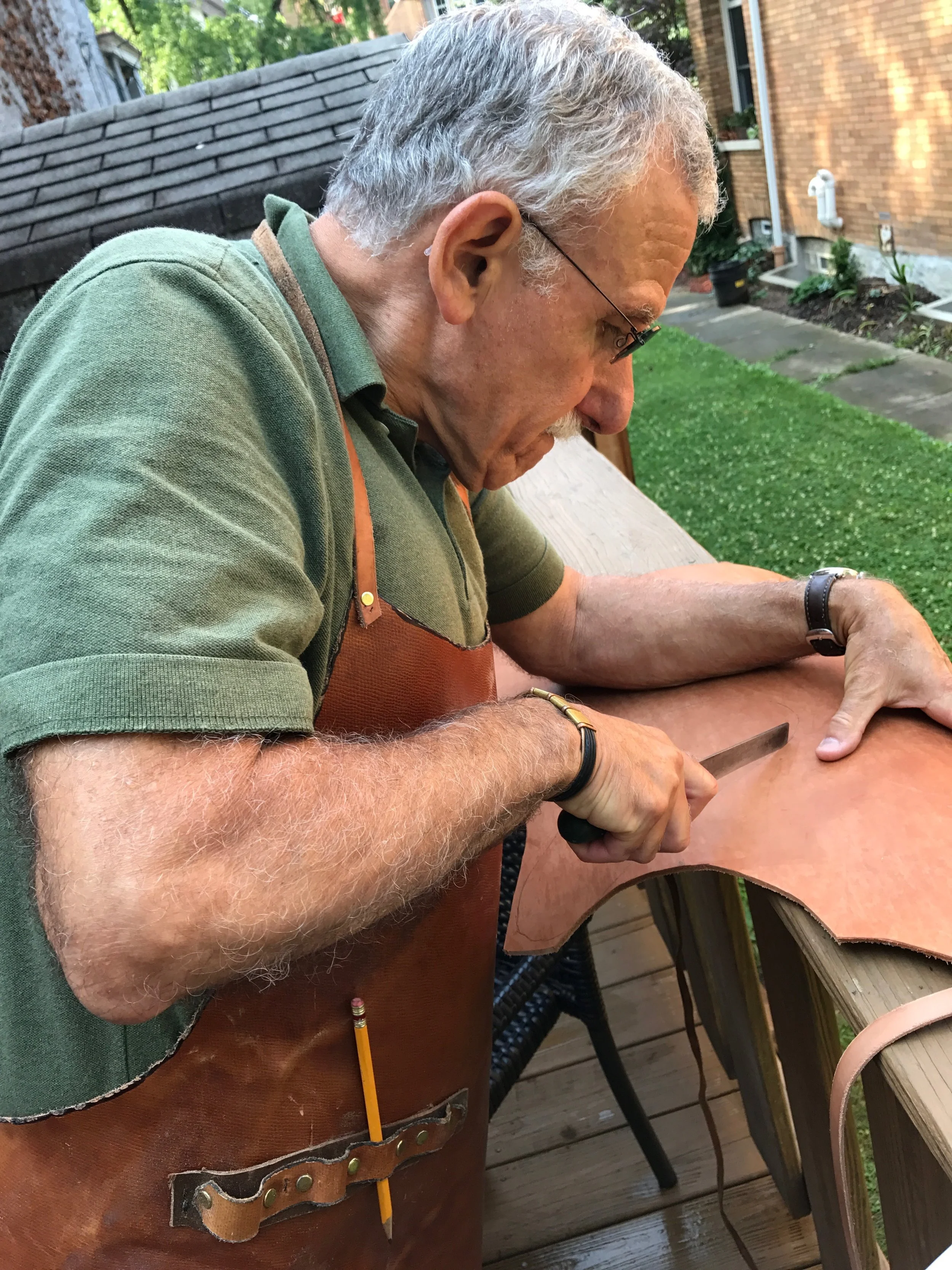 Eddie cutting out the soles of my sandals. That apron...
