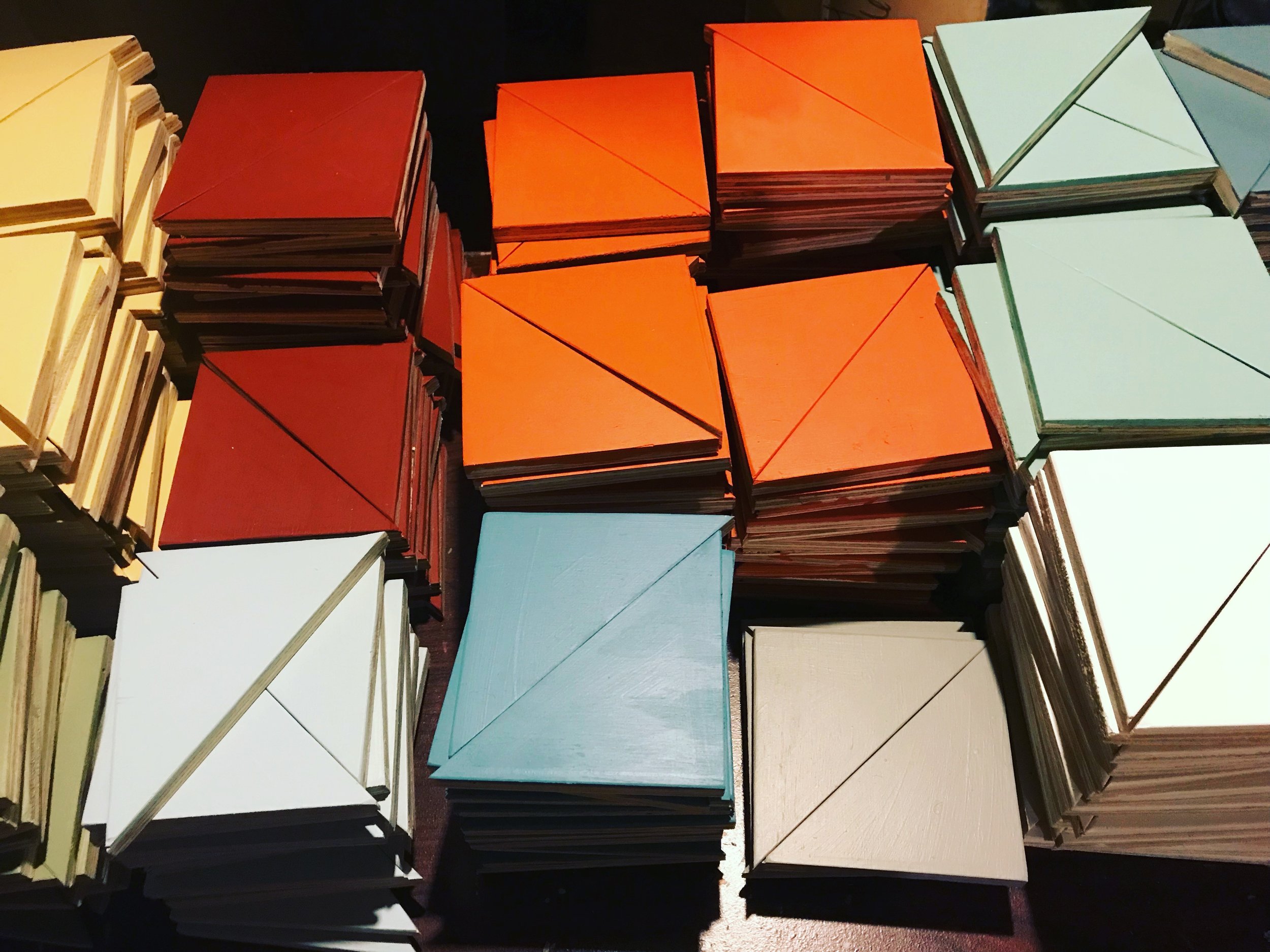 Stacks on stacks of painted quilt pieces ready to be assembled.