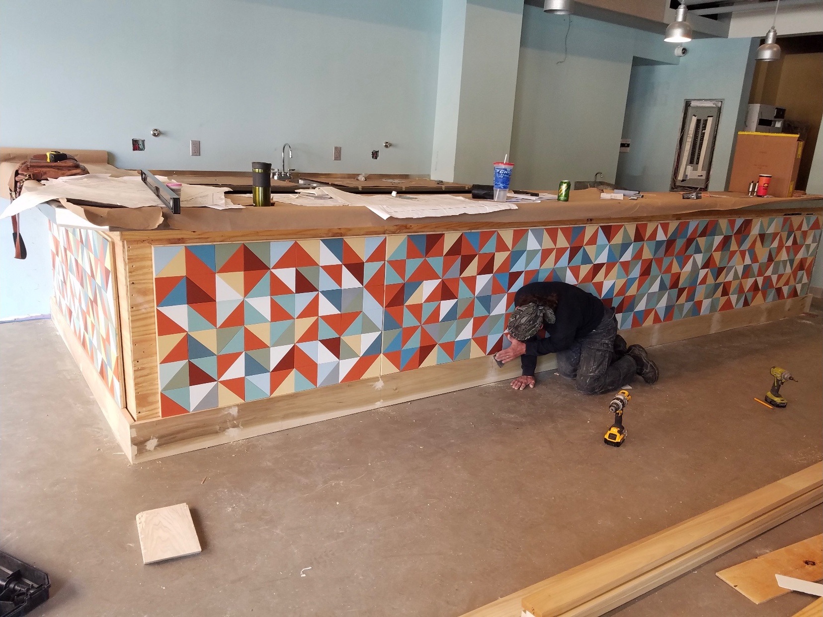 Carpenter trimming out the bar after installation.