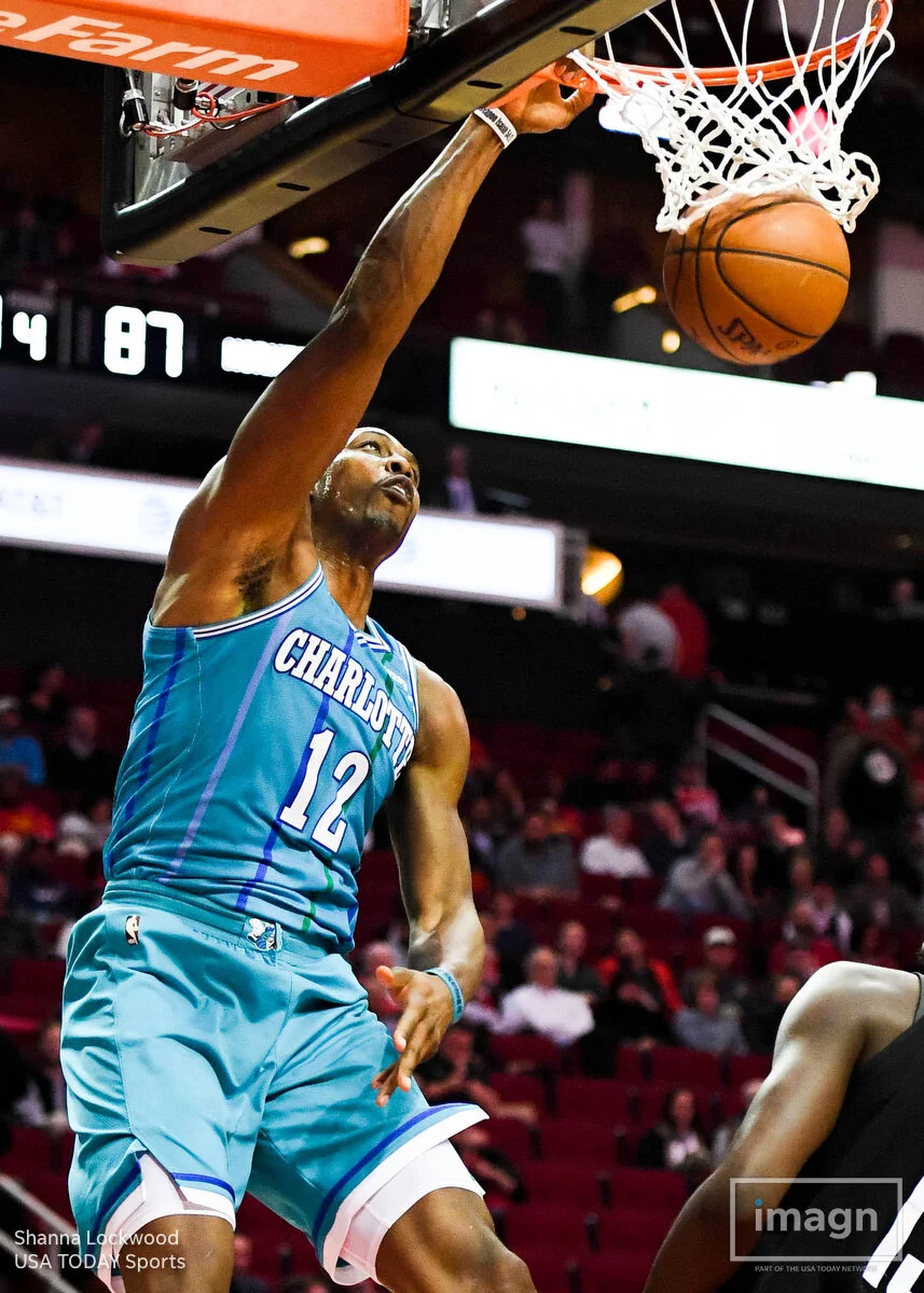 Dec 13, 2017; Houston, TX, USA; Charlotte Hornets center Dwight Howard (12) dunks as Houston Rockets guard James Harden (13), center Clint Capela (15), and guard Chris Paul (3) look on during the fourth quarter at Toyota Center. Mandatory Credit: Shanna Lockwood-USA TODAY Sports