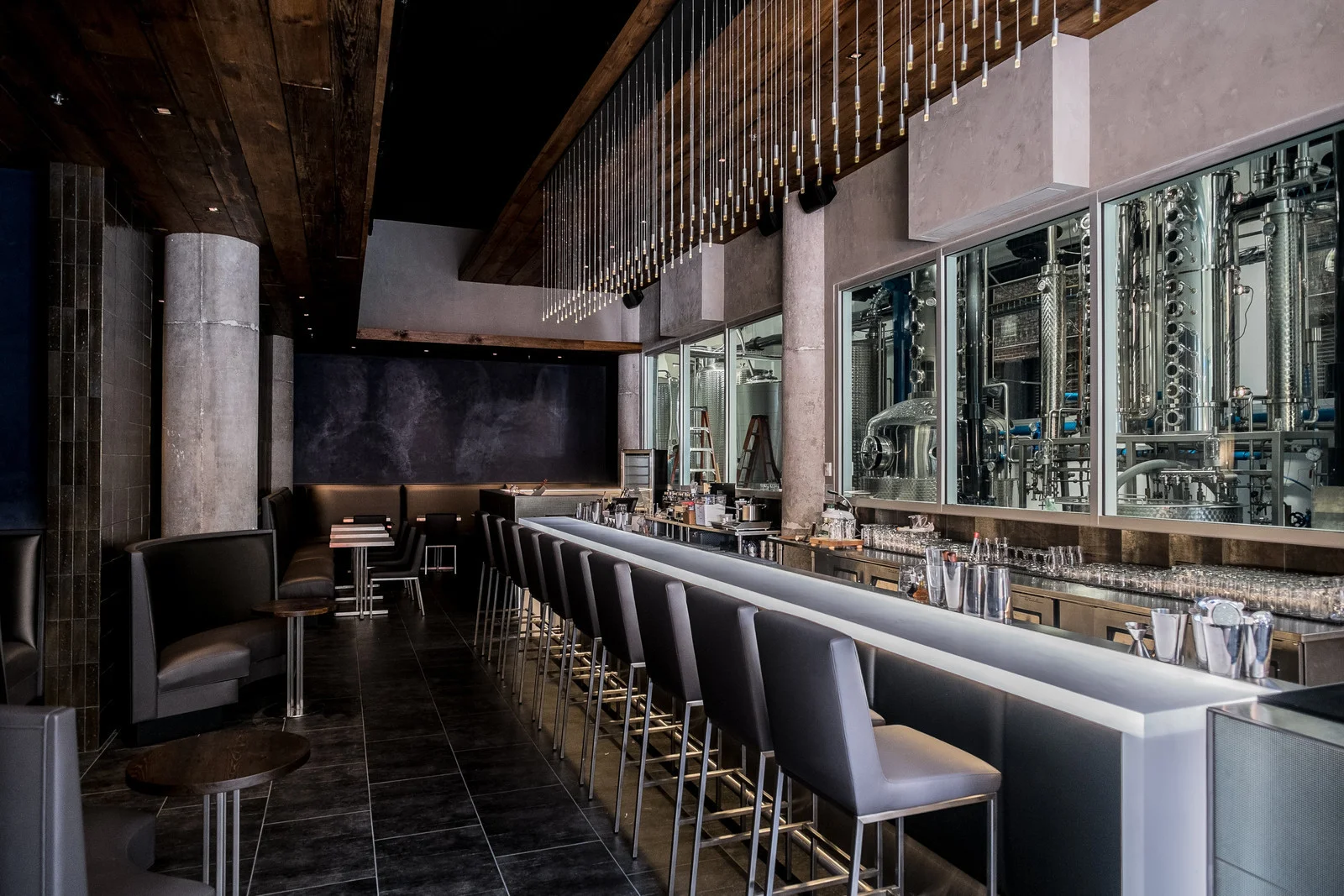 CH Distillery featuring salvaged wood planking which was used to clad the floating ceiling planes and help to buffer sound.