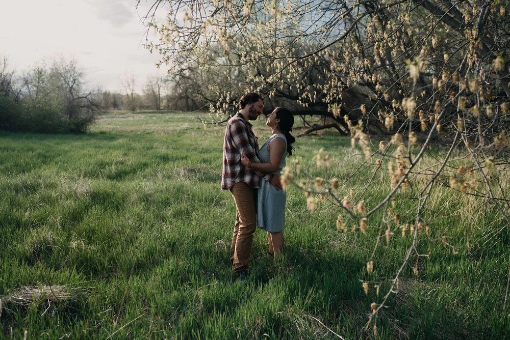 A happy engaged couple at an engagement session at Lee Martinez Park in Fort Collins, Colorado. Engagement portrait photography by Sonja Salzburg of Sonja K Photography.&nbsp;