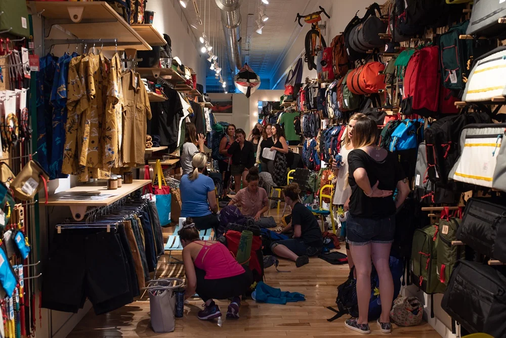 A packing party at the Wellbody Woman Summer TRIBE Program at Topo Designs in Fort Collins, Colorado. Corporate event photography by Sonja Salzburg of Sonja K Photography.&nbsp;