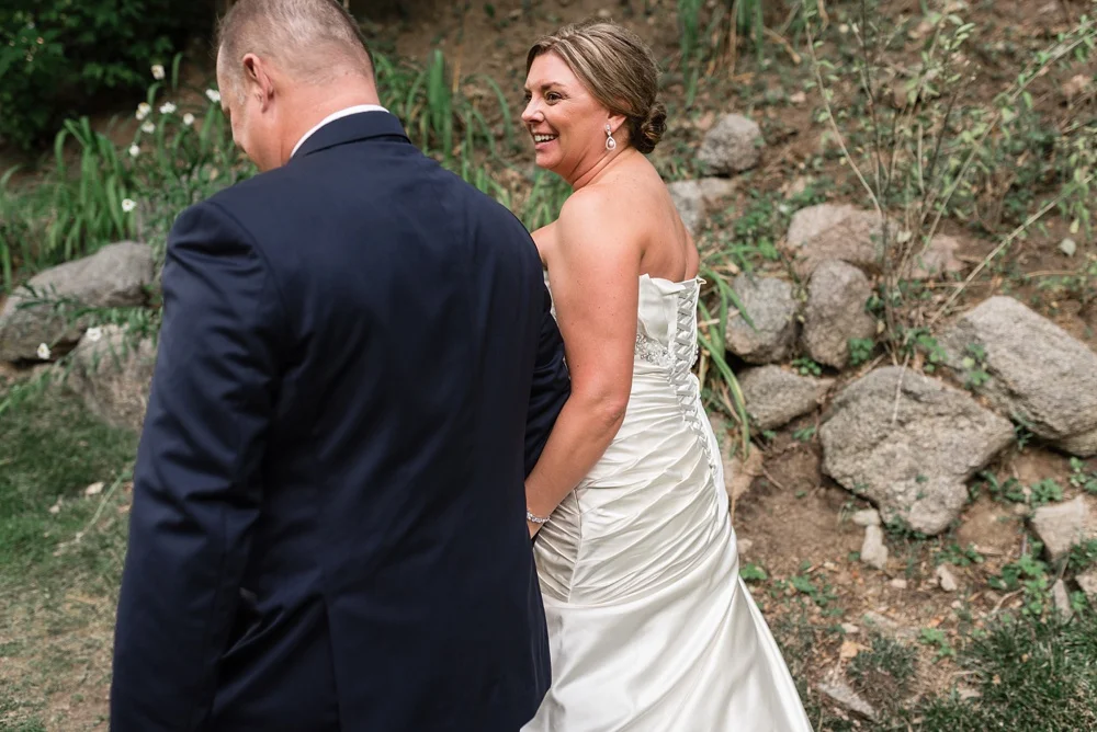 A bride and groom leave their wedding ceremony at Wedgewood Weddings on Boulder Creek outside of Boulder, Colorado. Wedding photography by Sonja Salzburg of Sonja K Photography.