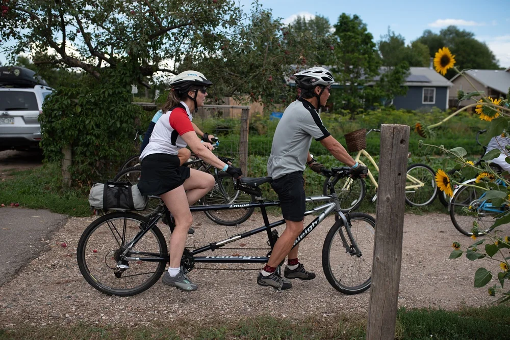 People arrive on bike to the Fortified Collaborations 3 Forks Progressive Farm Dinner in Fort Collins, Colorado. Event photography by Sonja Salzburg of Sonja K Photography.
