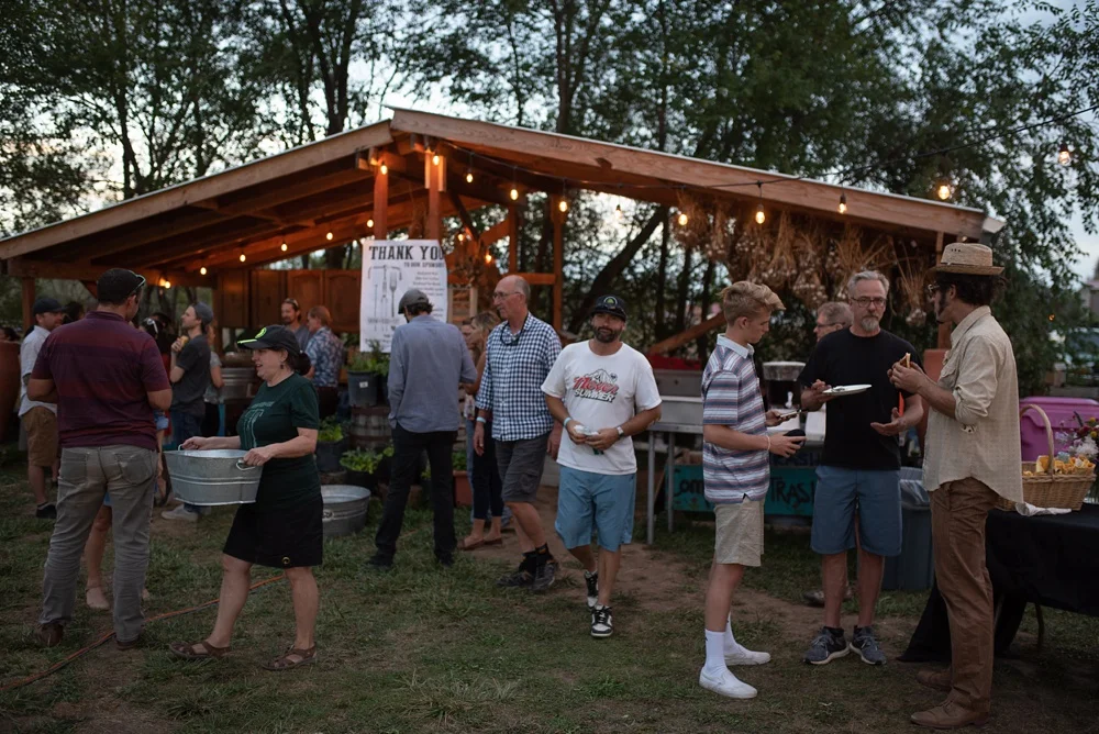 People eat and mingle at the Fortified Collaborations 3 Forks Progressive Farm Dinner at The Growing Project at the Burrow in Fort Collins, Colorado. Event and food and beverage photography by Sonja Salzburg of Sonja K Photography.