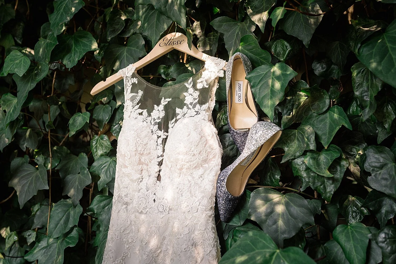 white floral dress and sparkly Jimmy Choo shoes hanging on ivy background