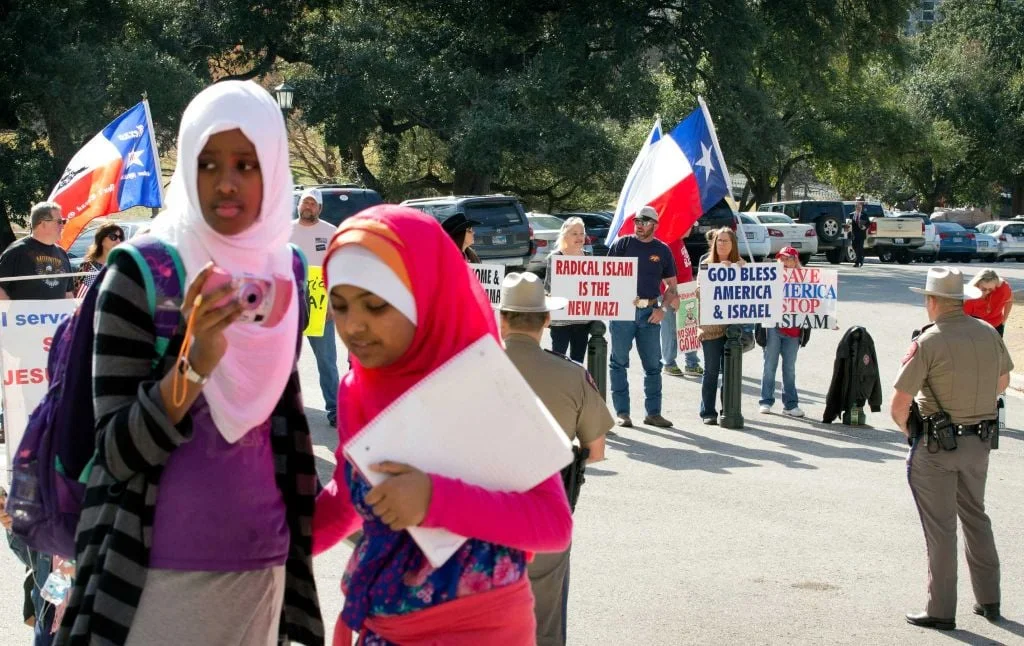 Amina Hassan, left, 11, of Grand Prairie, and Ayefa Klair, 10 of Irving, are faced with anti-Muslim protesters at the Texas Muslim Capitol Day in Austin, Texas. Photo: Jay Janner, Associated Press