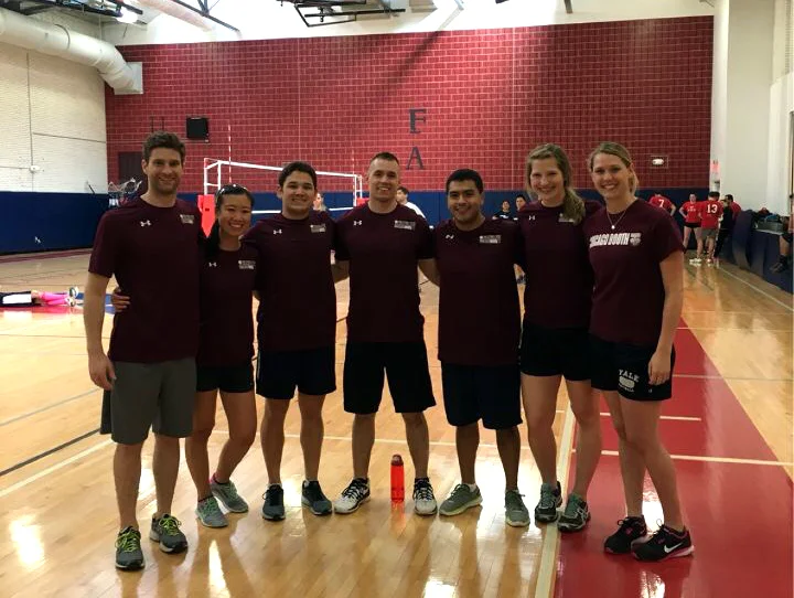 The Booth Volleyball Team stands in front of a red thimble for scale.