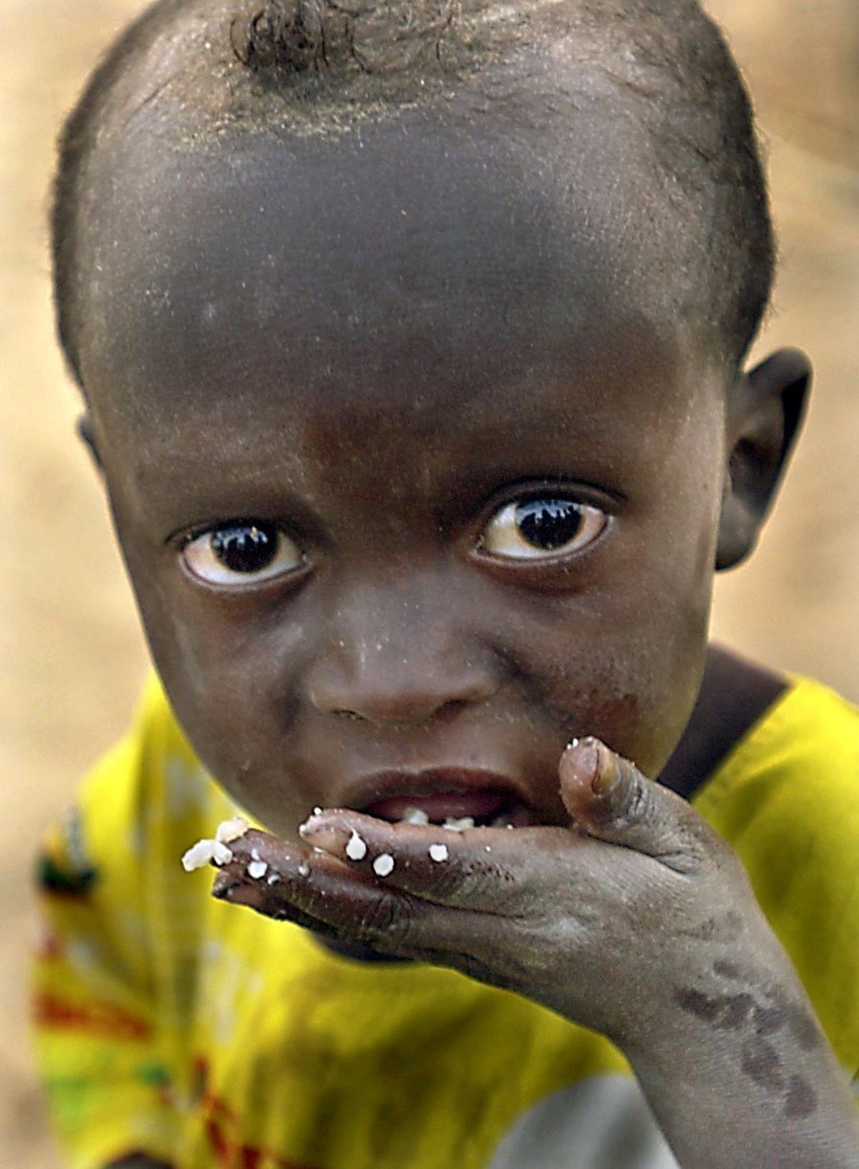 Mohamed Ag Ahmedou, 2, eats a few grains of rice for dinner in a village near the city of Lere in Mali. © Renée C. Byer/Sacramento Bee/ZUMAPRESS.com
