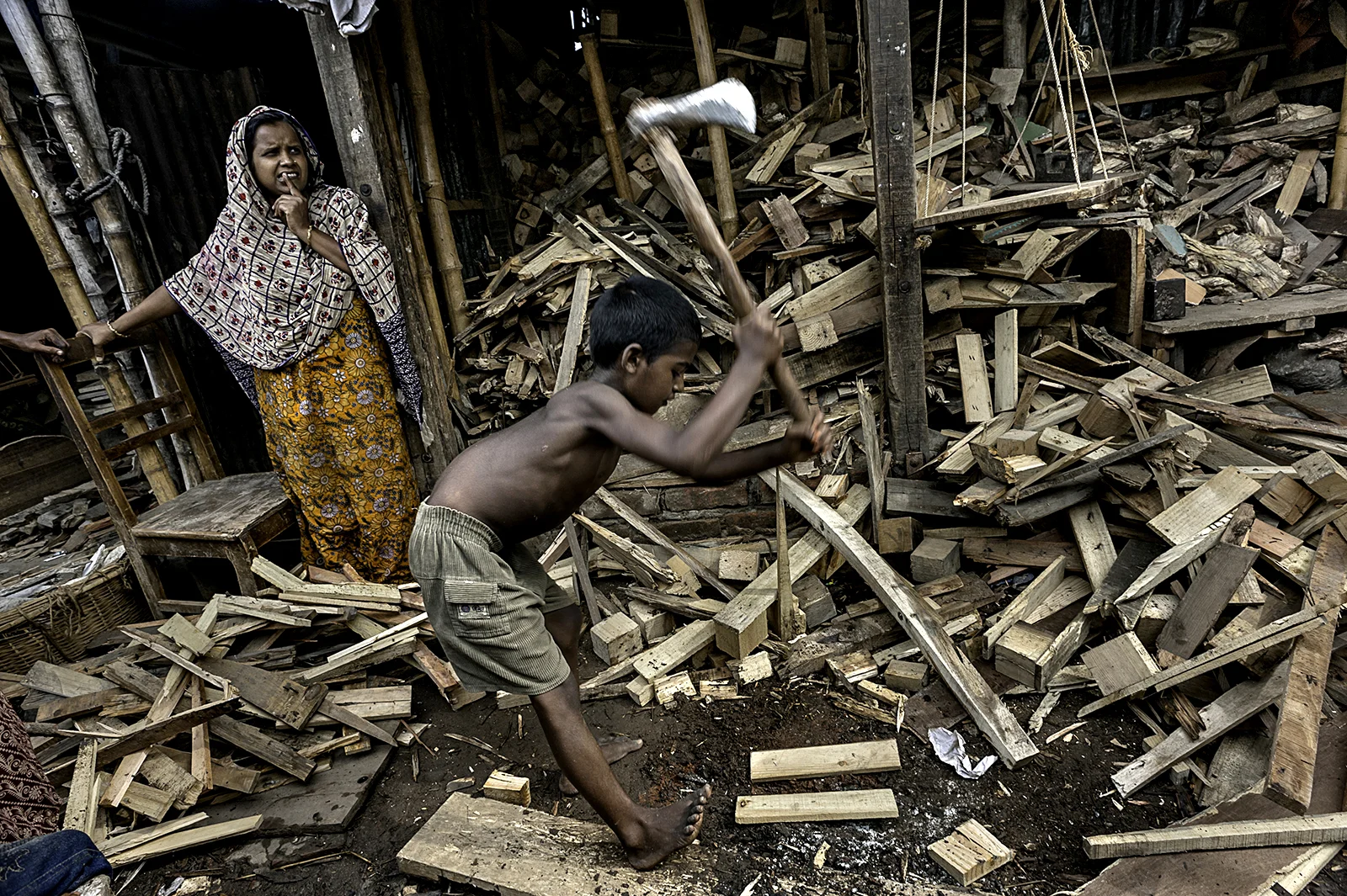In another area of Bangladesh, Saiful, 9, works splitting wood without shoes or any kind of protective gear. Few children who work as he does are given any rights in the workplace, for legally they are too young to be working at all. © Renée C. Byer