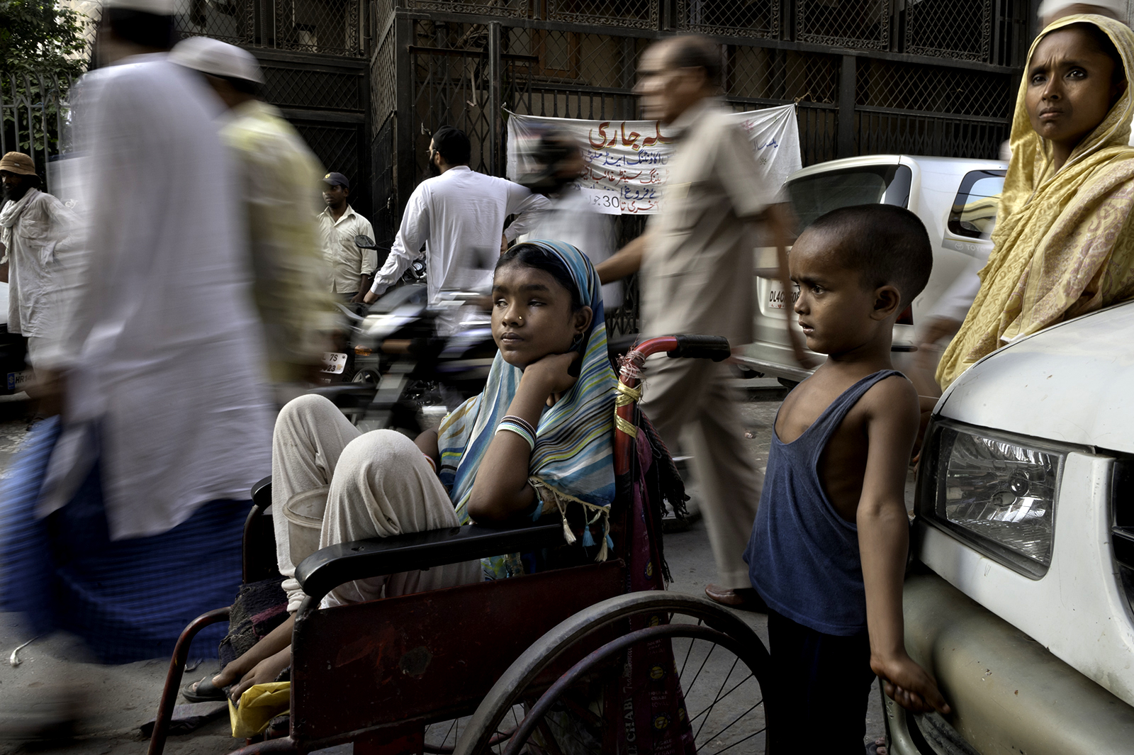 A sea of people walk by Hunupa Begum, 13, who has been blind for the past 10 years and lives close to the Nizamudin Bangala Masjid (Mosque) in New Delhi, India. © Renée C. Byer