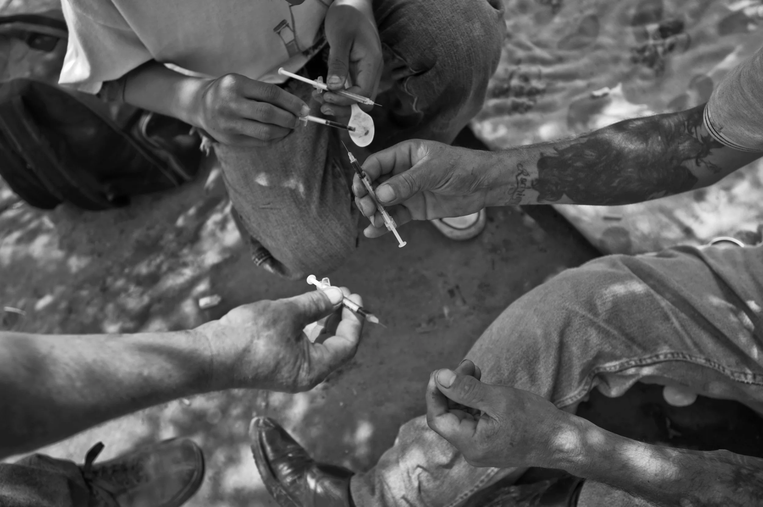 Mexican heroin addicts prepare needles along the Tijuana River in Mexico. ©Louie Palu/ZUMAPRESS.com