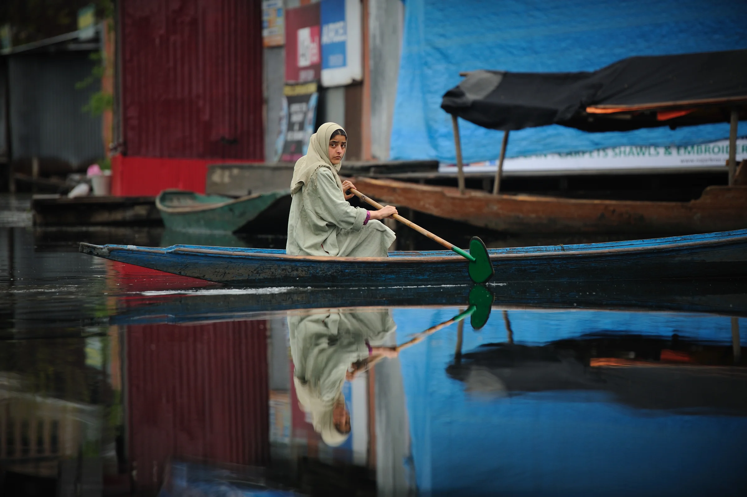 A Kashmiri girl paddles to the market before school in the early hours on Dal Lake in the troubled summer capital of Kashmir, Srinagar India. 2012 © Ami Vitale