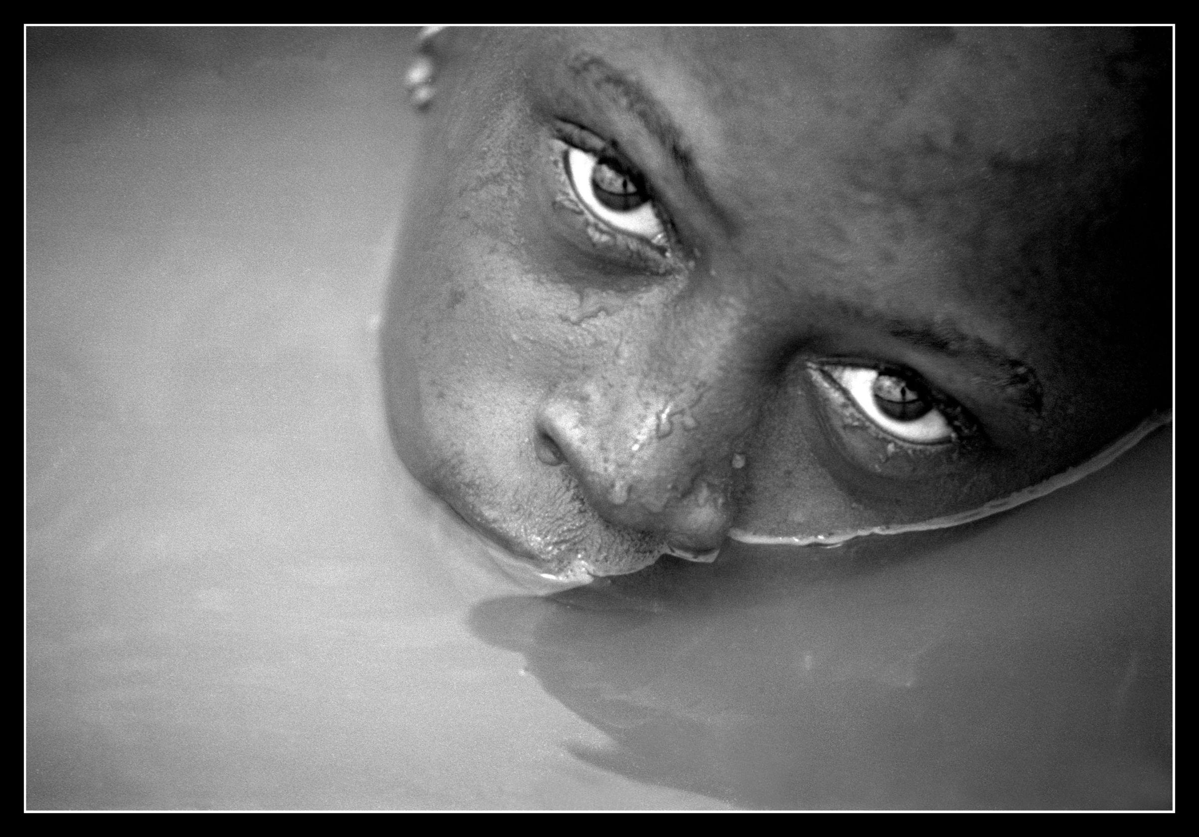 Adema Balde washes near her family's rice fields in the village of Dembel Jumpora located in the West African country of Guinea Bissau. She died as a teenager later that year after trying to escape an arranged marriage. 2004 © Ami Vitale