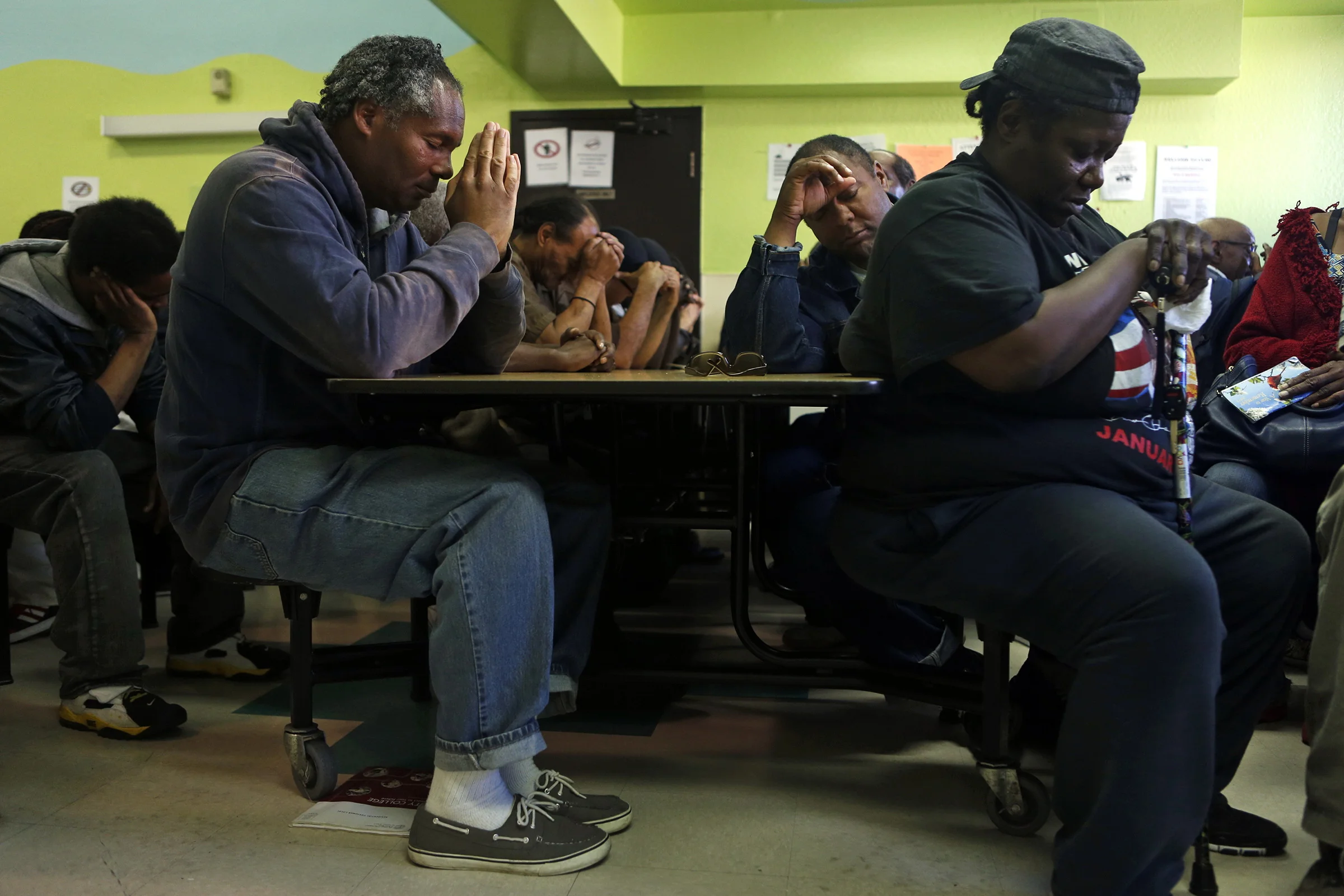 (left to right) Phillip House, Richard Lofton and Beverly Fails pray before receiving dinner at Mother Brown's Kitchen next to a proposed shelter at 2115 Jennings Street in in the Bayview district of San Francisco. © Scott Strazzante/San Francisco Chronicle