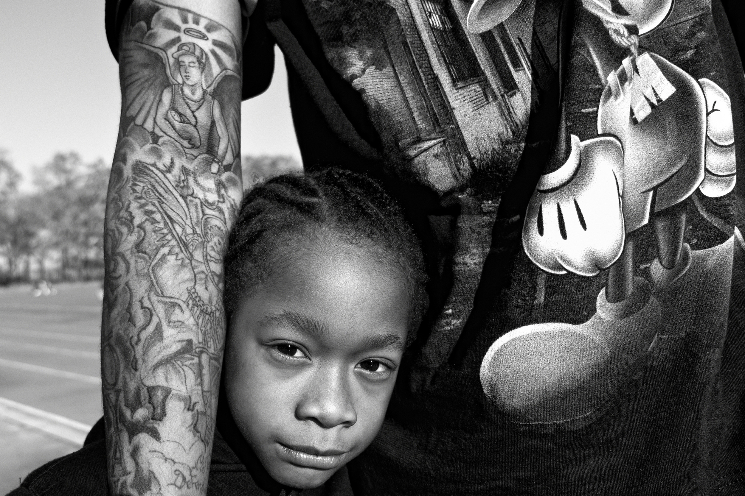 Jerell Willis holds his son Fidel. Jerell's right arm has a tattoo depicting him as Fidel's guardian angel. "I got the tattoo when I won custody of Fidel," says Jerell. "The tattoo is a reminder of my duty to protect him." New York, NY, USA. November 2011. © Zun Lee