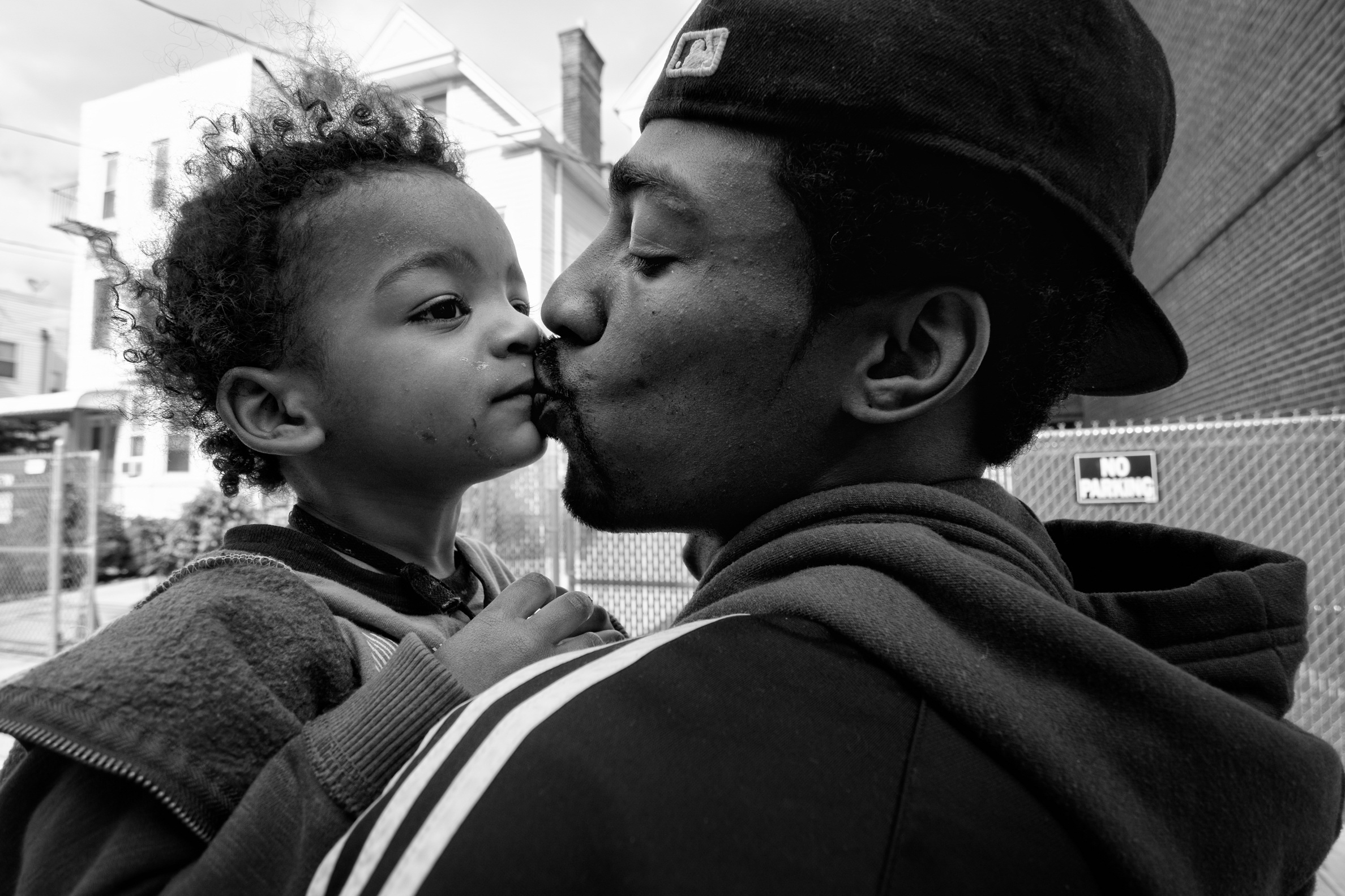 Guy Miller kisses his son "Chum Chum" while running daytime errands. Bronx, NY. 2013. © Zun Lee