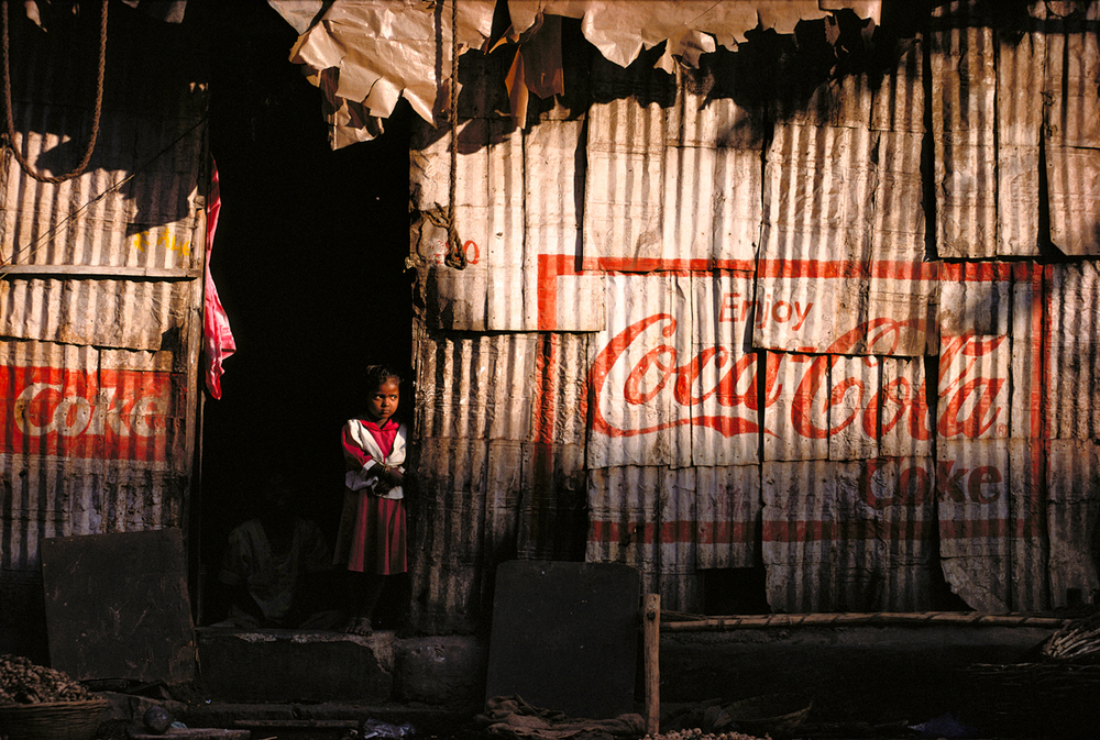  An Indian girl stands in the doorway of her Mumbai slum 1999 © Joe McNally 