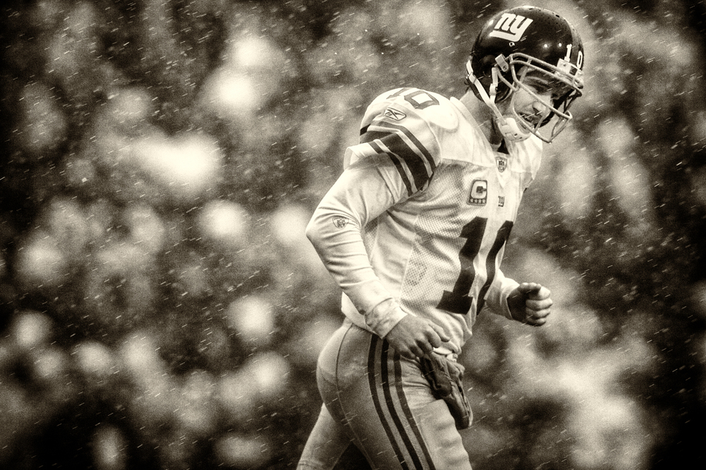   Giants QB Eli Manning runs through the driving rain and sleet during New York's 38-21 defeat of the The Buffalo Bills at Ralph Wilson Stadium in Orchard Park, NY. December 23, 2007&nbsp;© David Bergman  