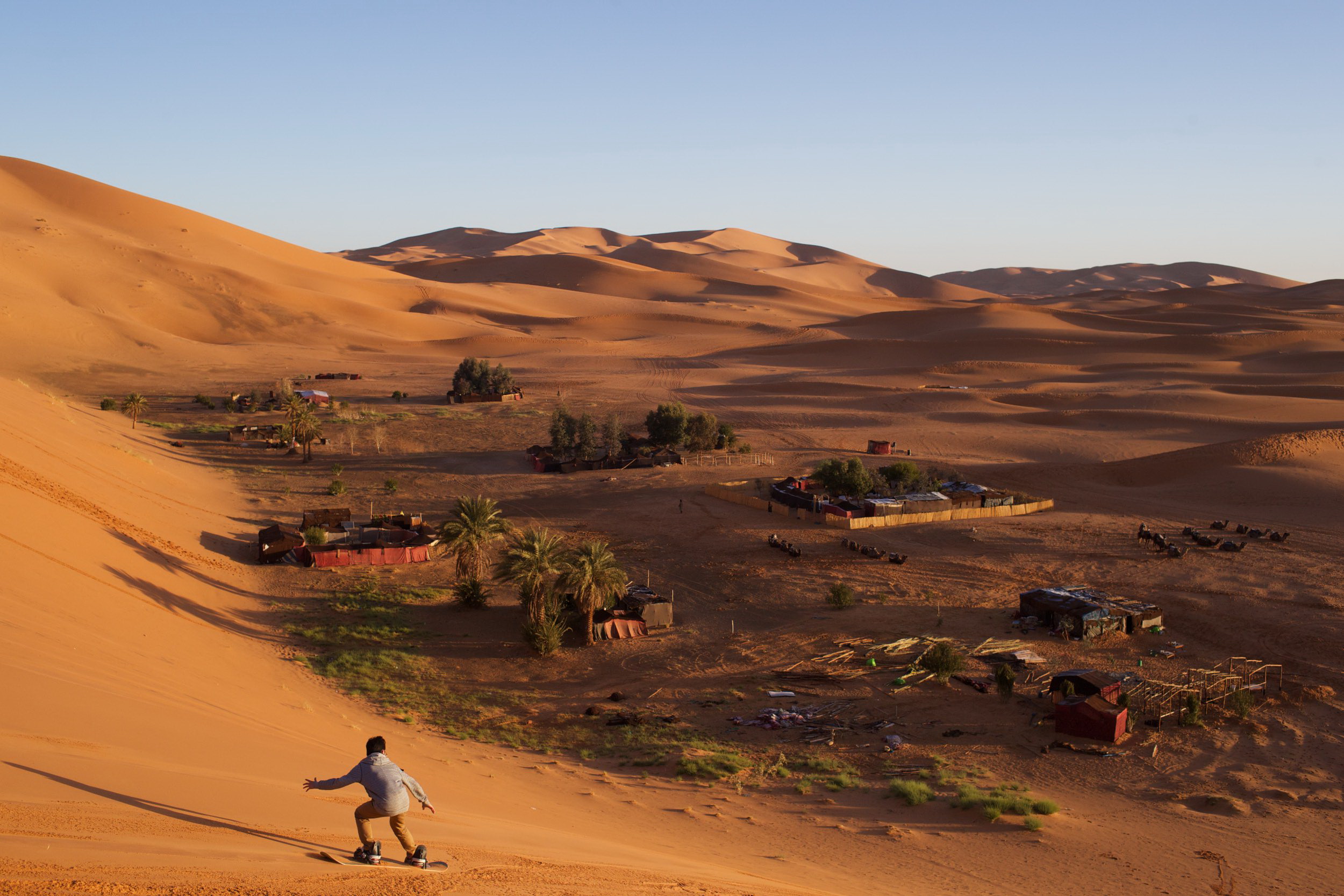 A Chinese tourist in the dunes of the Sahara Desert tries his hand at sandboarding for the first time during an overnight camping trip with classmates. 2nd place POYi this year, Recreational Sports. © Sol Neelman