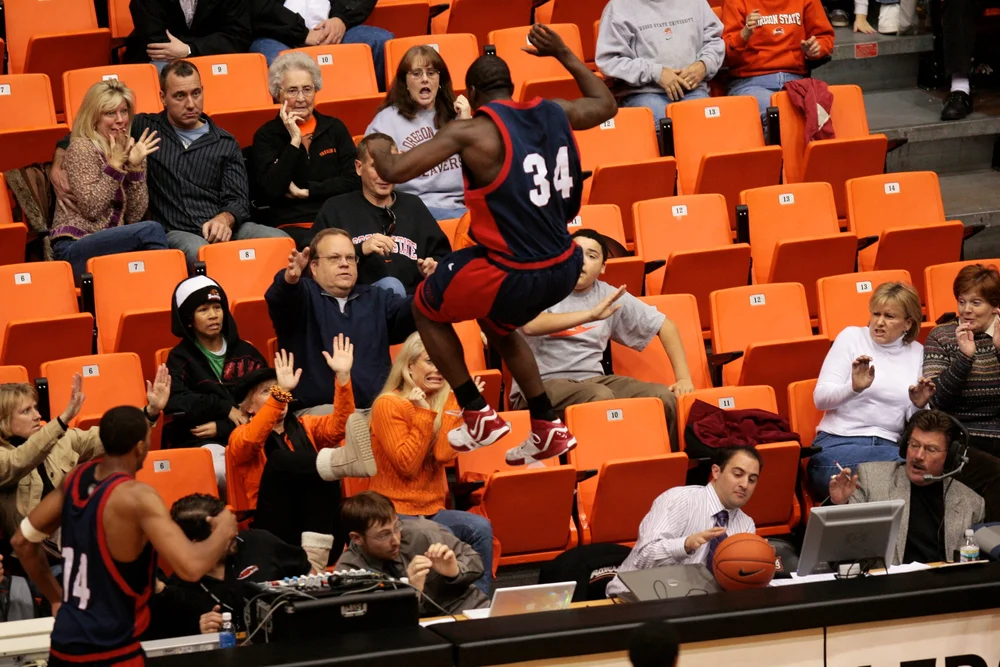   A player from Fresno State leaps into the stands while chasing after a loose ball.&nbsp;© Sol Neelman/The Oregonian  