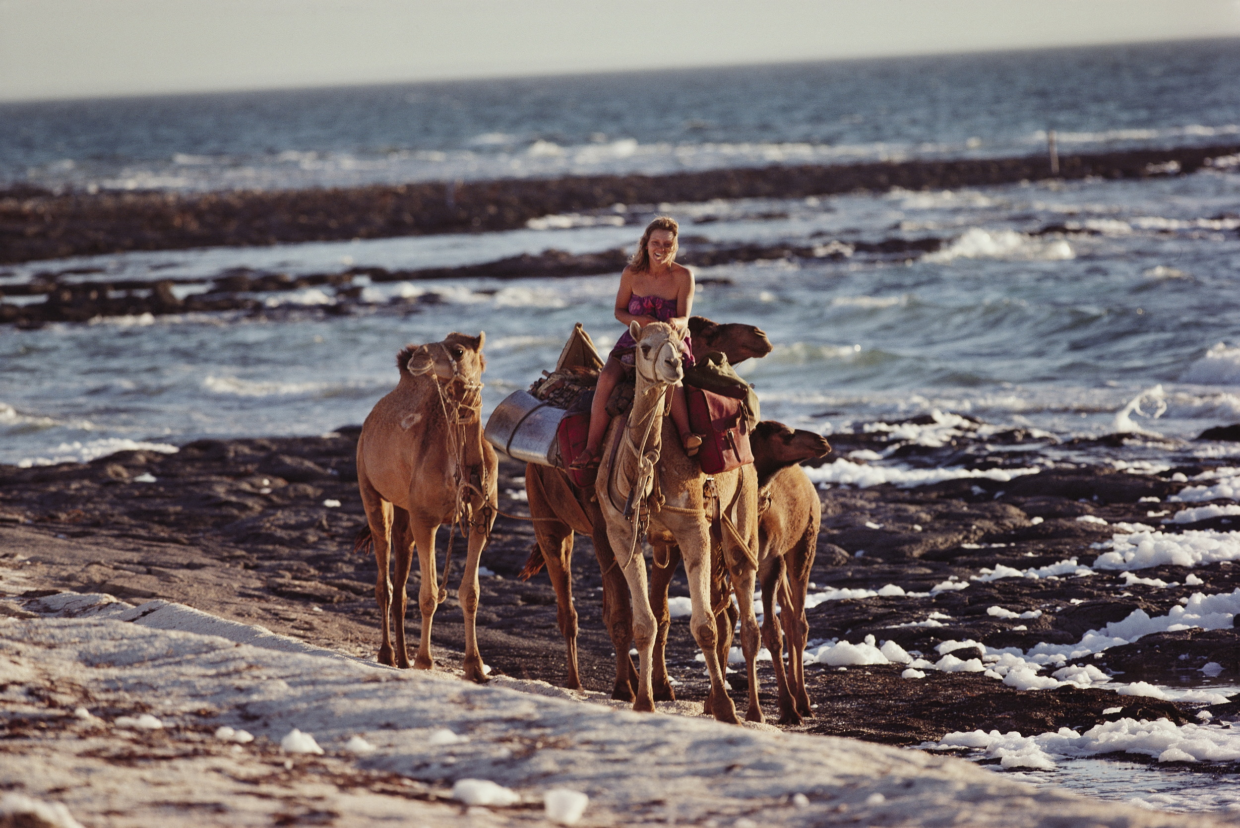After nine months and 2700 arduous kilometers, it was late afternoon on a perfect day when Robyn and the camels had their first glimpse of the Indian Ocean. The camels had never seen any body of water bigger than a puddle and their eyes bulged at the infinite expanse in front of them. Their arrival marked the end of an extraordinary odyssey. © Rick Smolan/Against All Odds Productions
