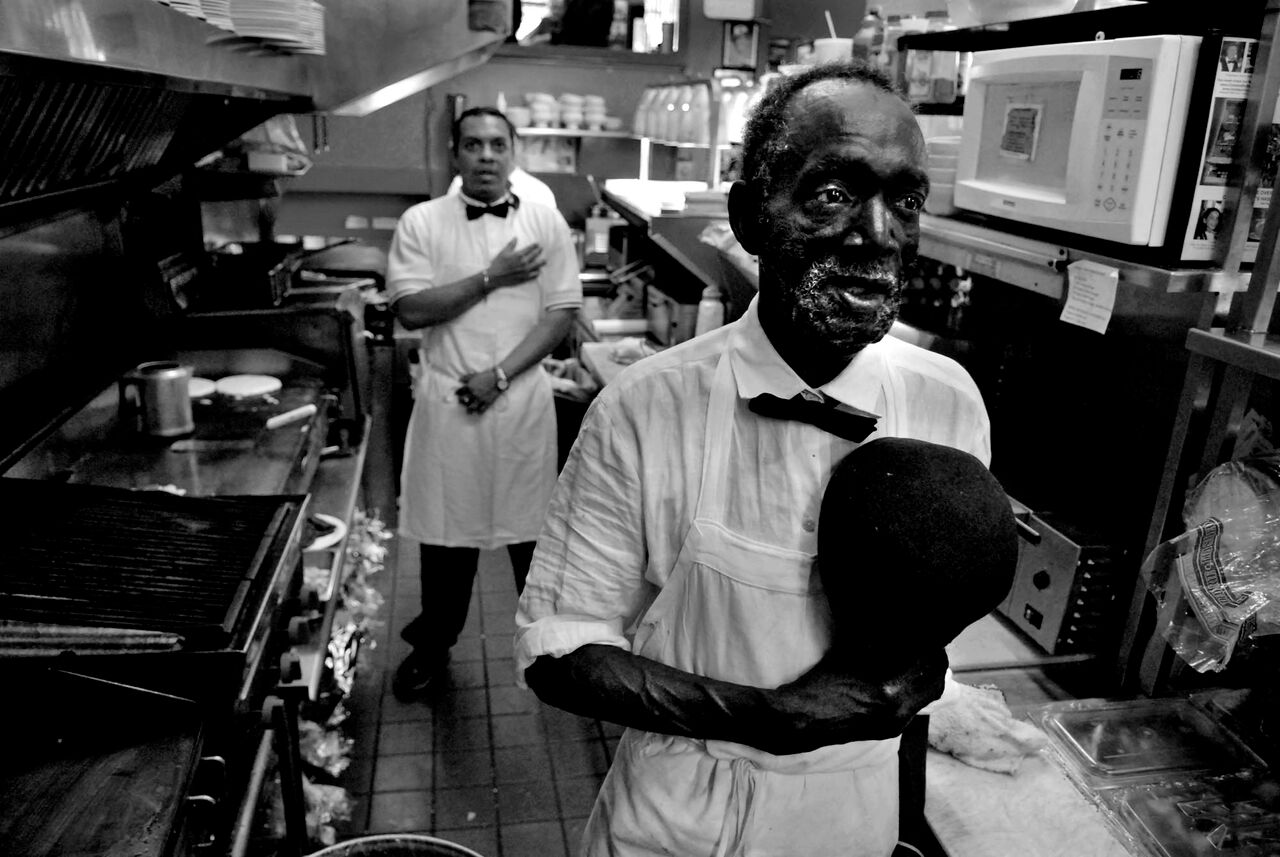 Tom Hall, 65, has been a cook for eleven years at Chick and Ruth's Delly on Main Street in Annapolis, Md. He pauses during the morning breakfast rush to say the Pledge of Allegiance. © Mary F. Calvert/ ZUMAPRESS.com