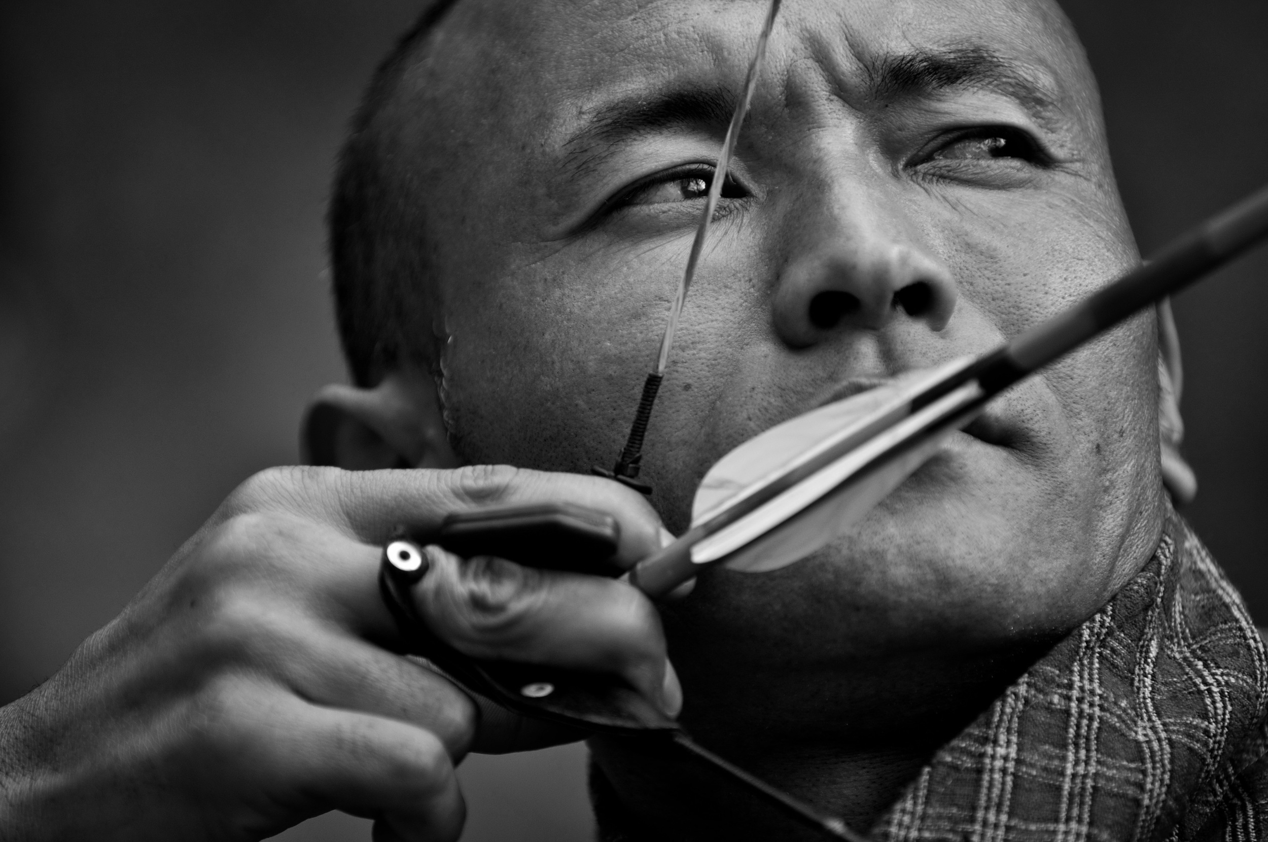 Kinzang, (just one name) 42, takes aim during a friendly match outside the capitol city of Thimphu, Bhutan. © Mary F. Calvert/ ZUMAPRESS.com