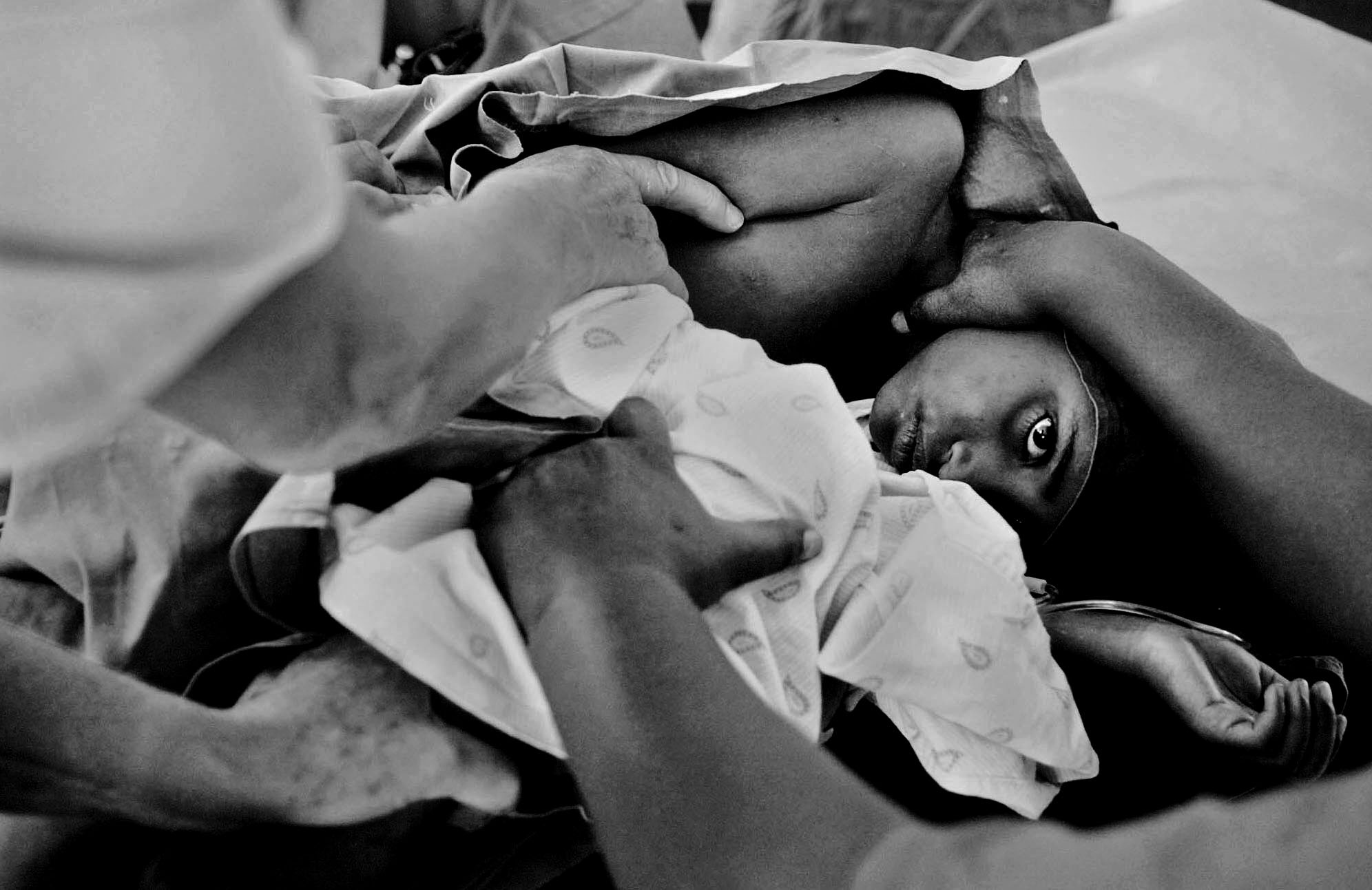 Trail of Tears: Fighting Obstetric Fistula in Ethiopia: Nurses and Dr. Andrew Browning hold down Alem while she bravely gets a spinal block before her surgery. She is a beautiful and babbly 7-year-old who was raped by a family friend on her way to