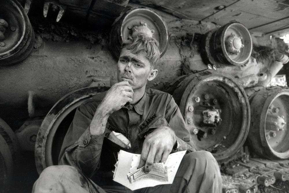  An American soldier reads a letter from home, while taking a break from repairing a tank tread. Lang Vei, South Vietnam, March 1971 &nbsp;© 2015 David Burnett/Contact Press Images 