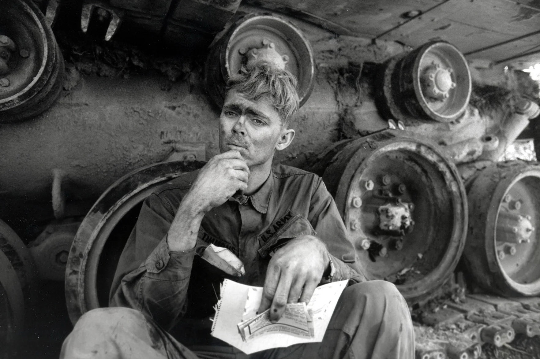 An American soldier reads a letter from home, while taking a break from repairing a tank tread. Lang Vei, South Vietnam, March 1971 © 2015 David Burnett/Contact Press Images