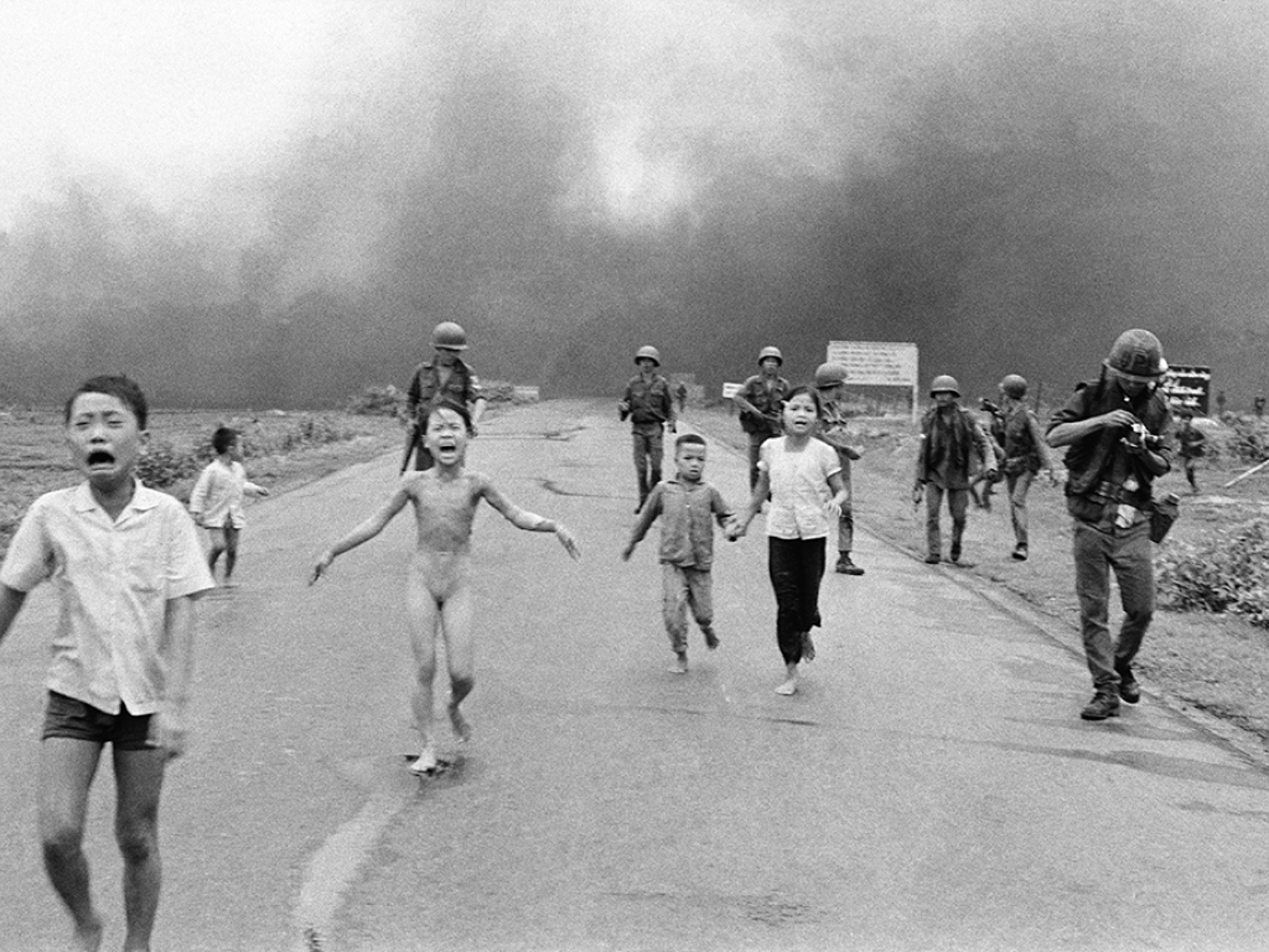 Trang Bang, Vietnam, June 8, 1972: 9-year-old Kim Phuc runs naked in the street after a napalm attack. One of David Burnett's images from that fateful day is included in the gallery. © Nick Ut/AP